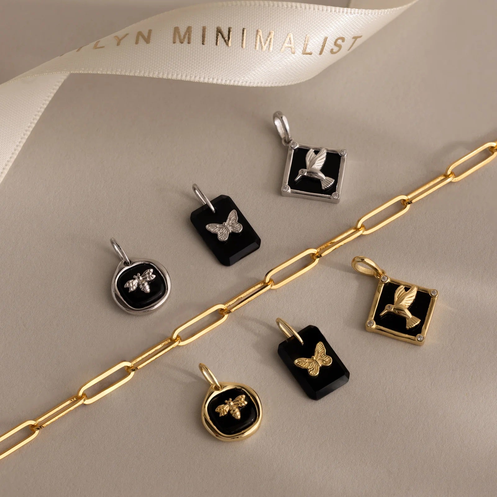 Jewelry set with pendants and a gold chain on a neutral background